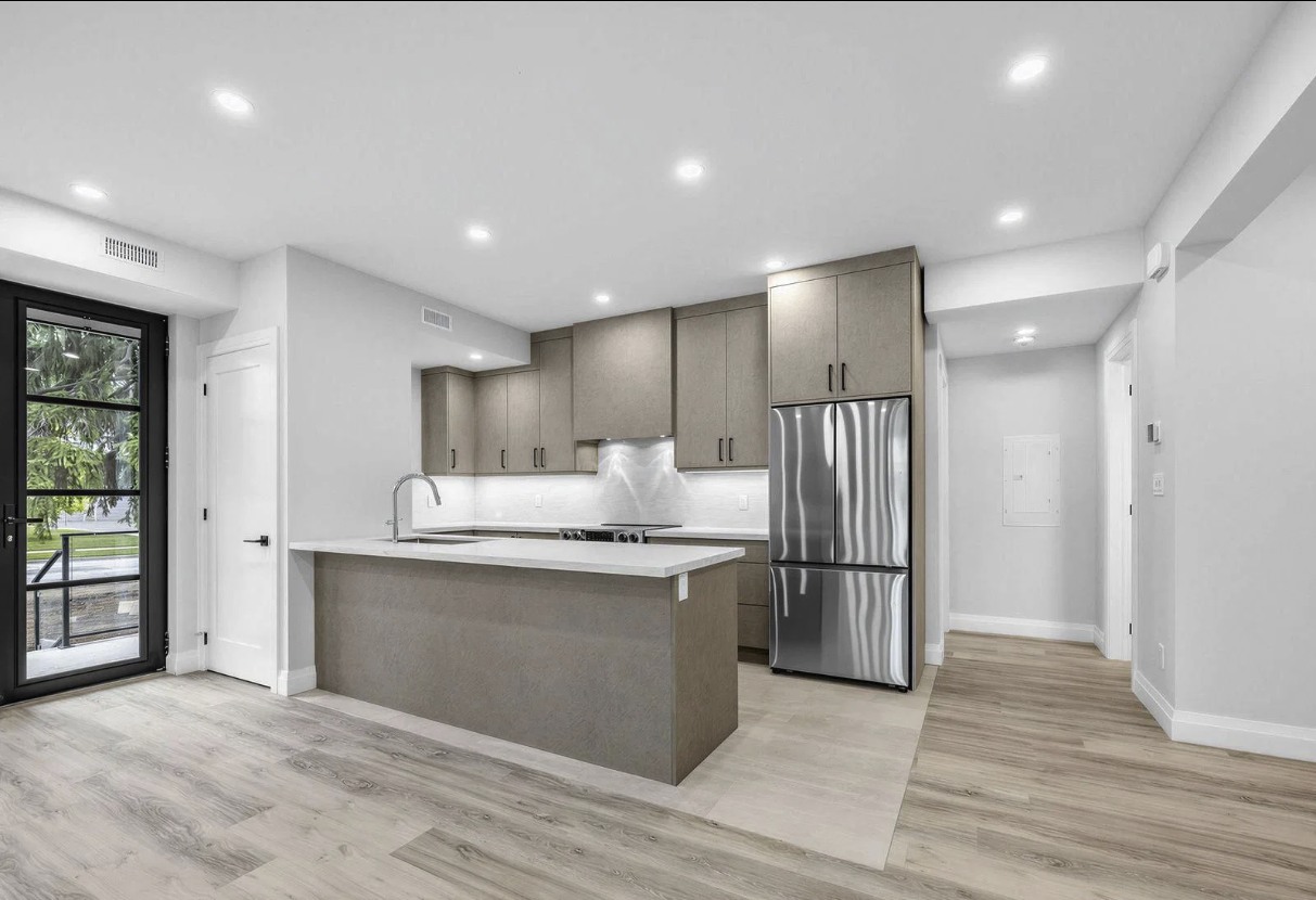 Kitchen island with quartz counter and stainless appliances